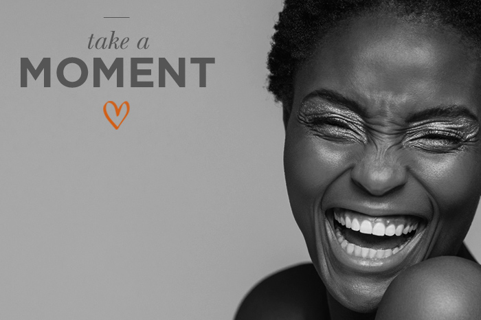 Smiling woman's glowing face with 'take a moment' phrase