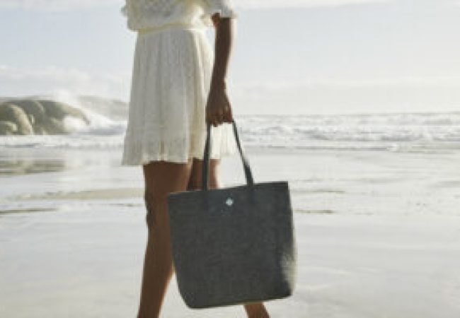 Woman walking at the beach with a handbag