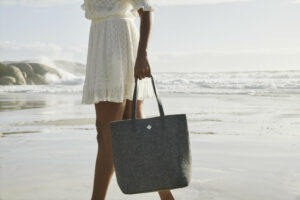Woman walking at the beach with a handbag